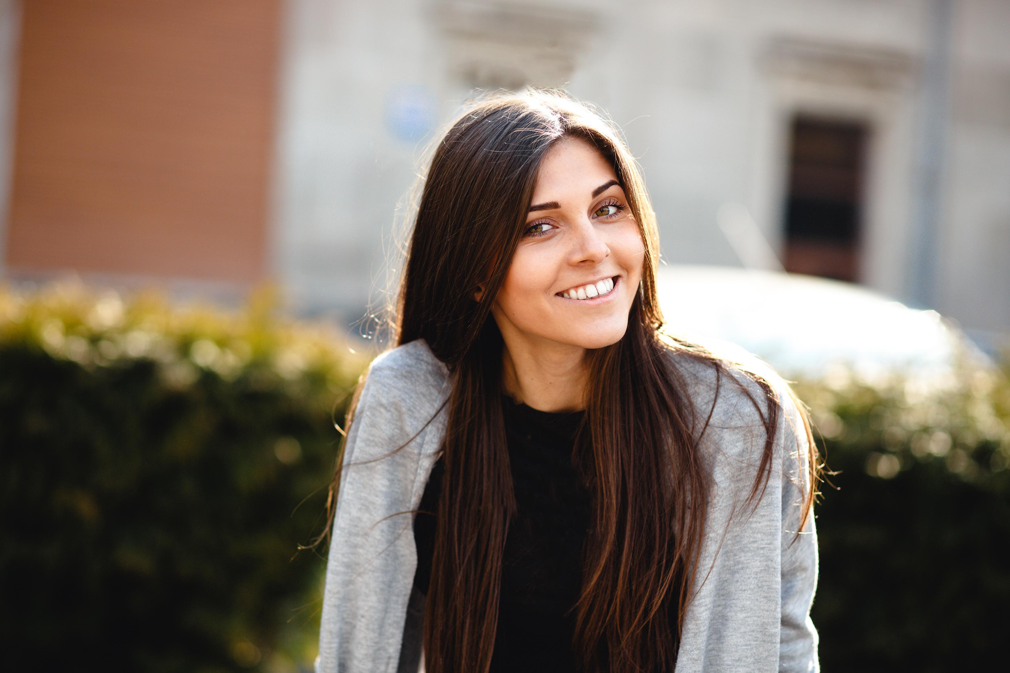 A confident young woman smiling outdoors